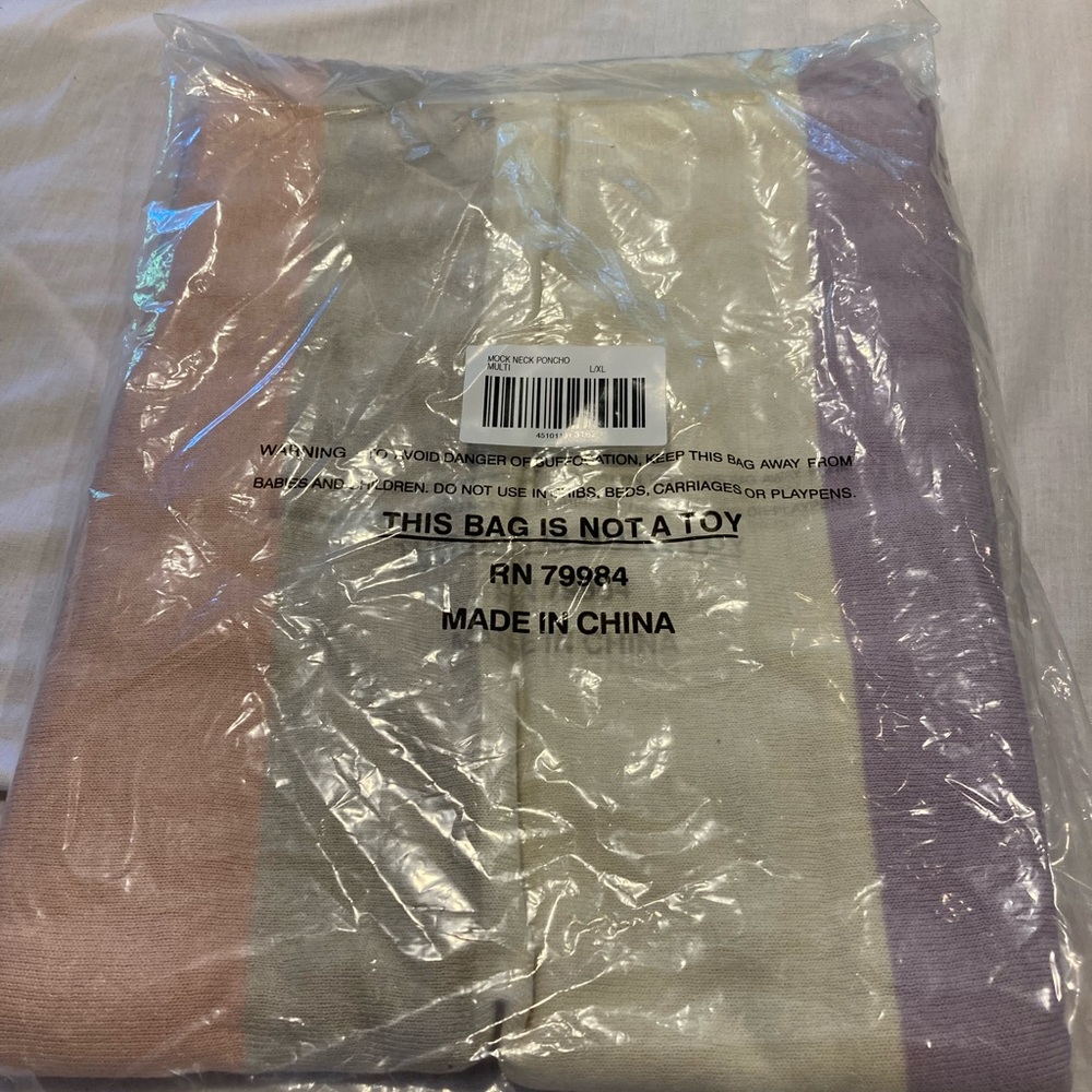 Chico’s Lightweight knit poncho in multicolor vertical stripes.